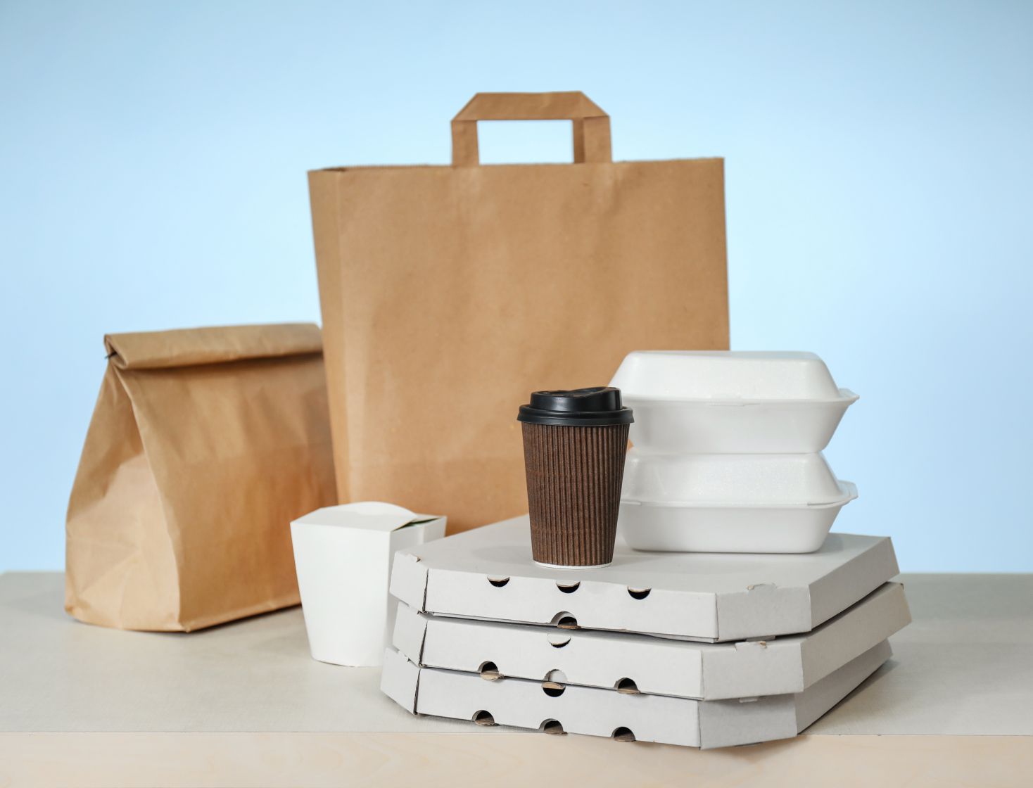 さまざまな種類の紙製品：紙袋、箱、カップ。